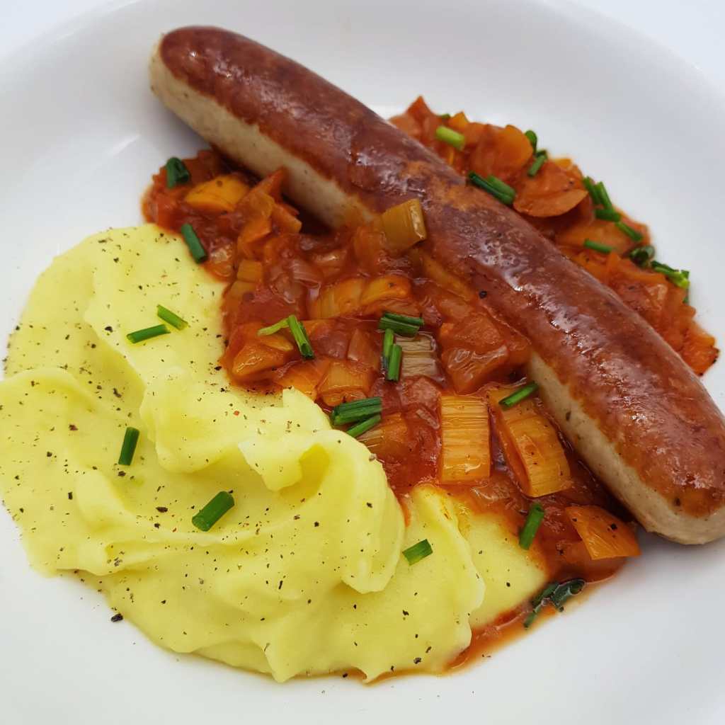 German fried sausages with leek and onion vegetables