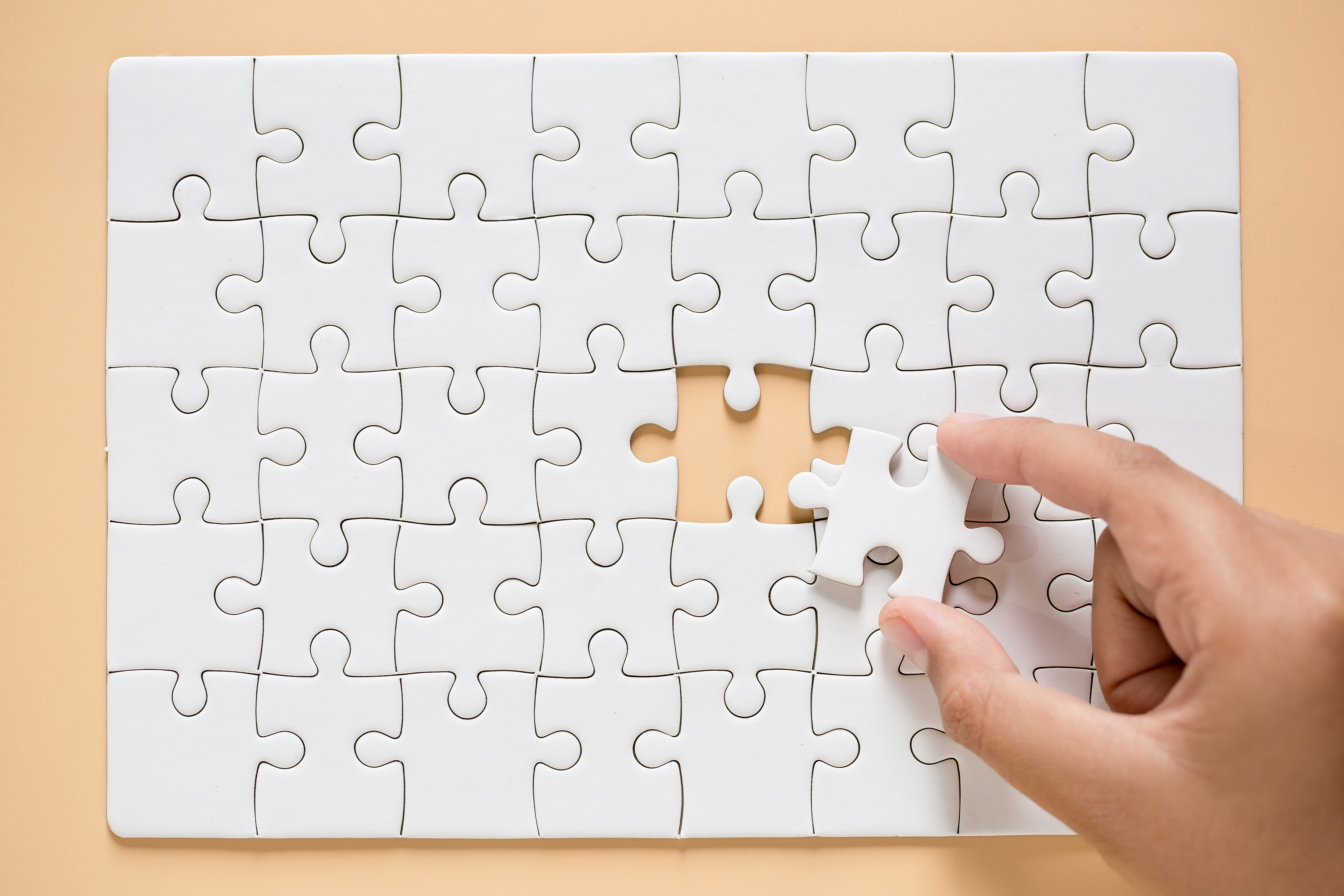 hand-connecting-puzzle-pieces-table-background (1).jpg
