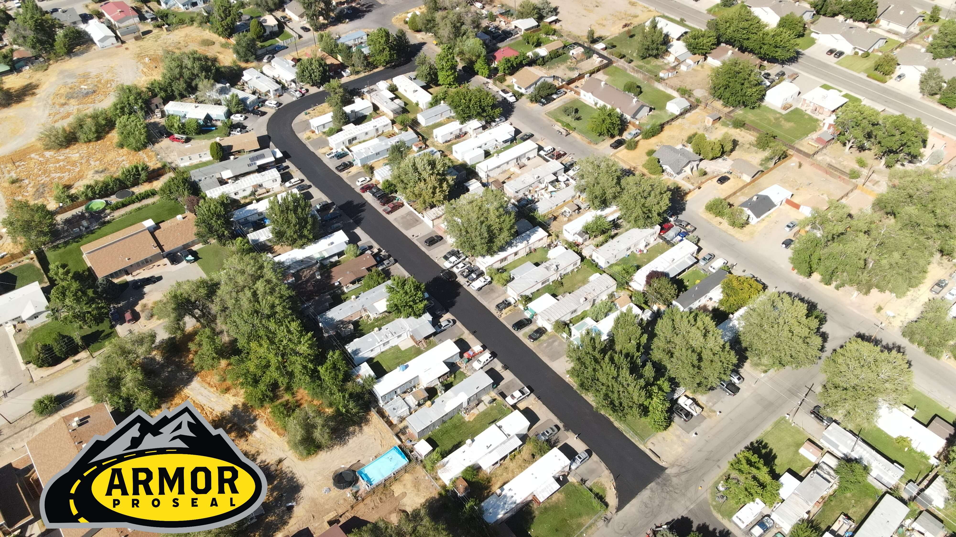 Highway service area resurfacing in Green River, UT, with Armor Proseal equipment and crew improving commercial infrastructure with durable desert-condition asphalt.