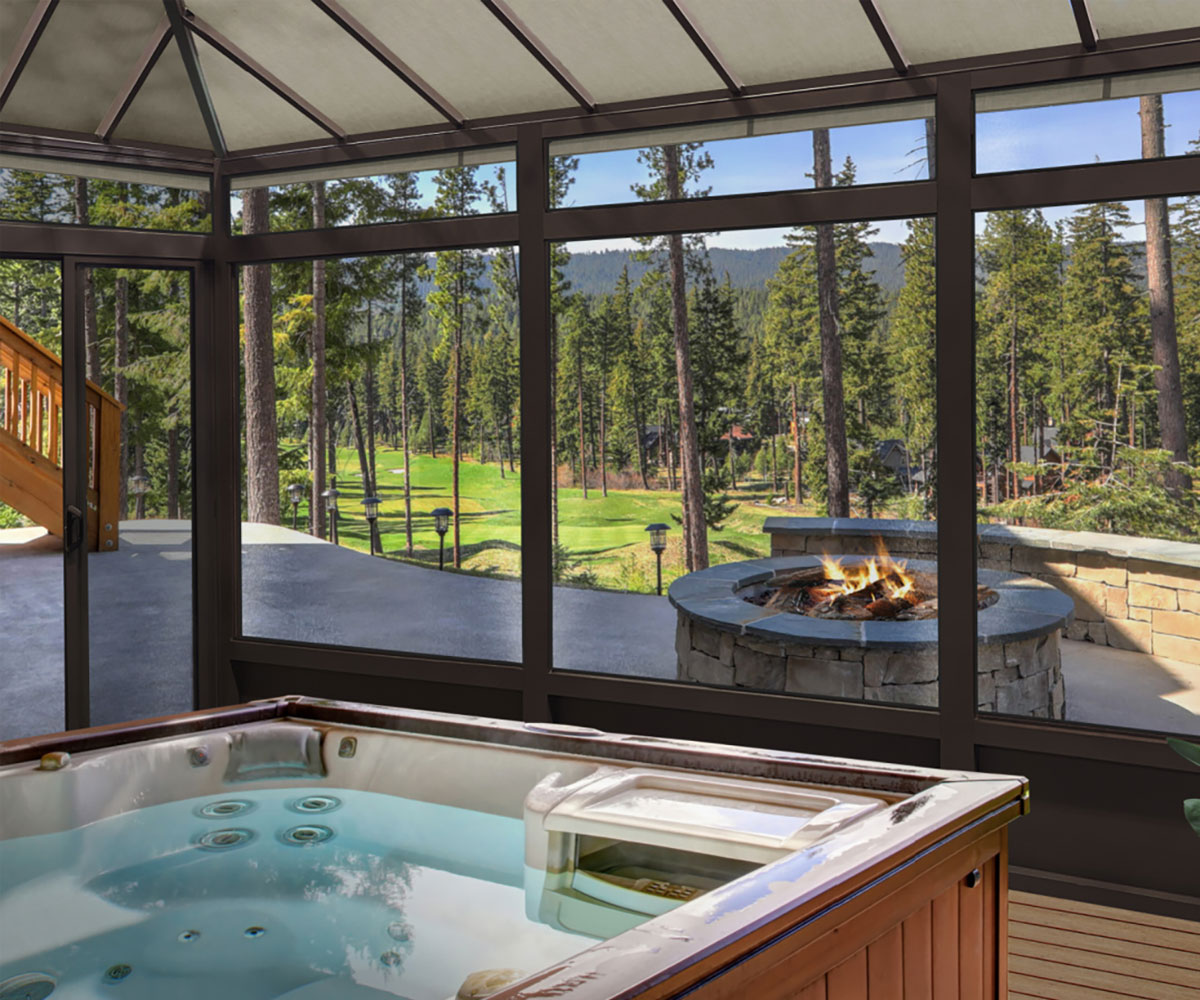 Columbus Ohio enclosed sunroom with windows and hot tub looking at outdoor fire pit