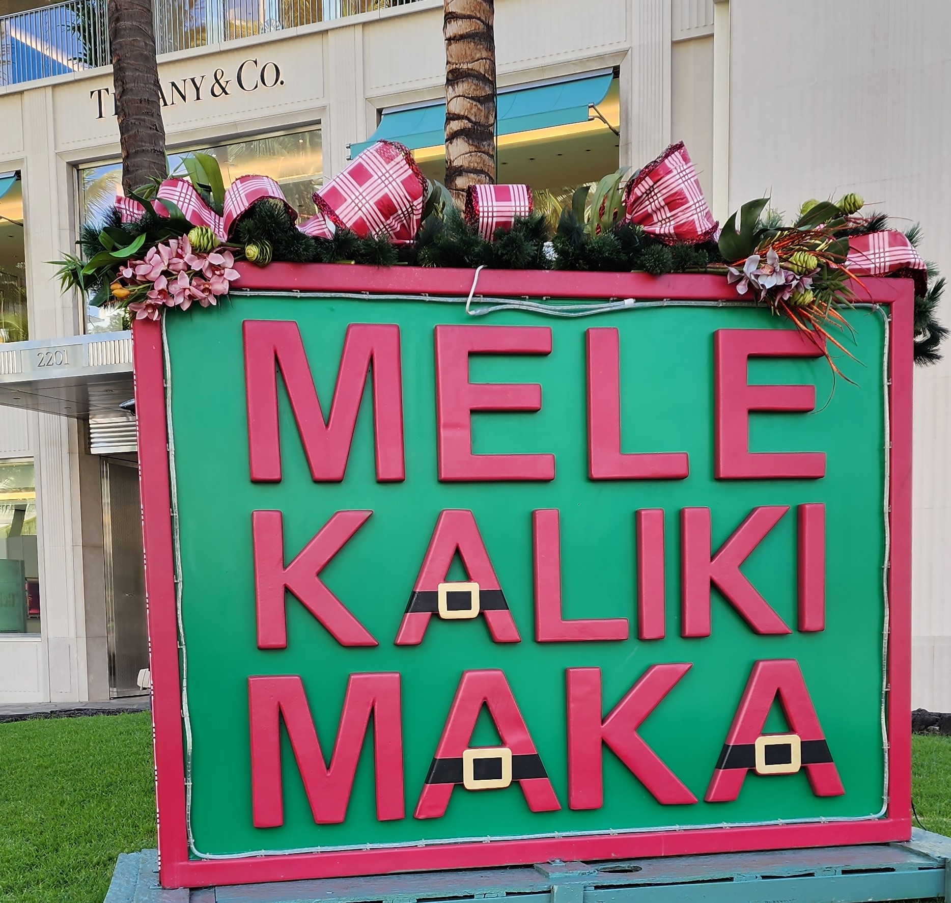Mele Kalikimaka Christmas sign in Waikiki Hawaii in front of a Tiffany's store.