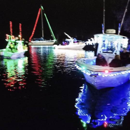Boats with Christmas lights at the Christmas in the River City boat parade in Moss Point, MS
