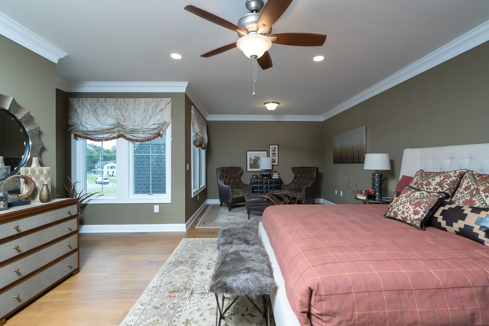 Luxury Townhome - Roomy primary suite featuring a cozy sitting area and a large custom walk-in closet