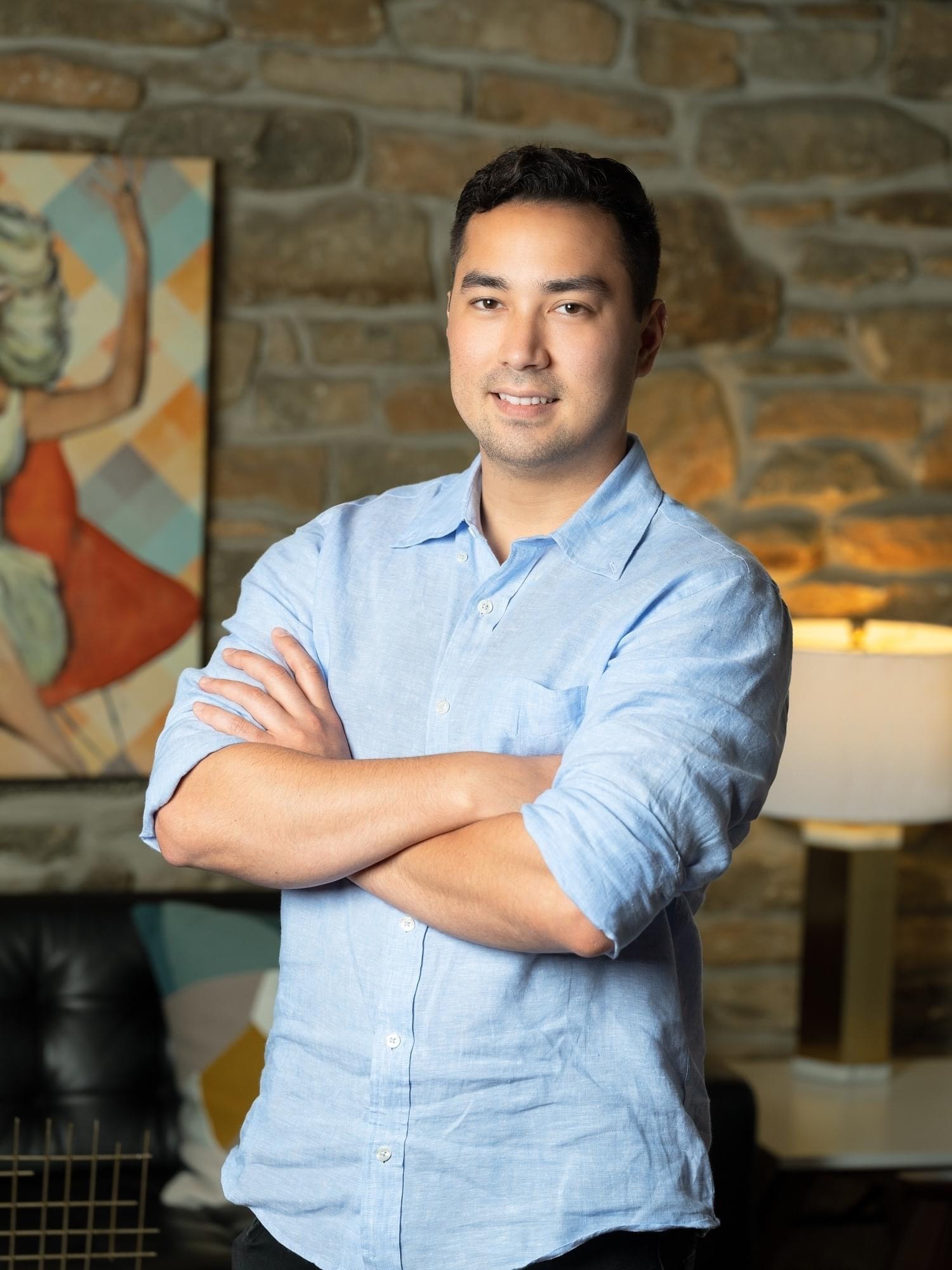 a woman wearing a black jacket and a red scarf is smiling for the camera .