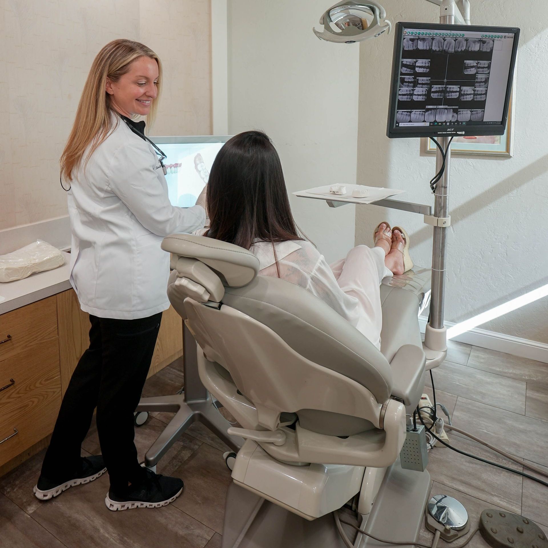 A man with a beard is wearing a white shirt and smiling with his arms crossed.