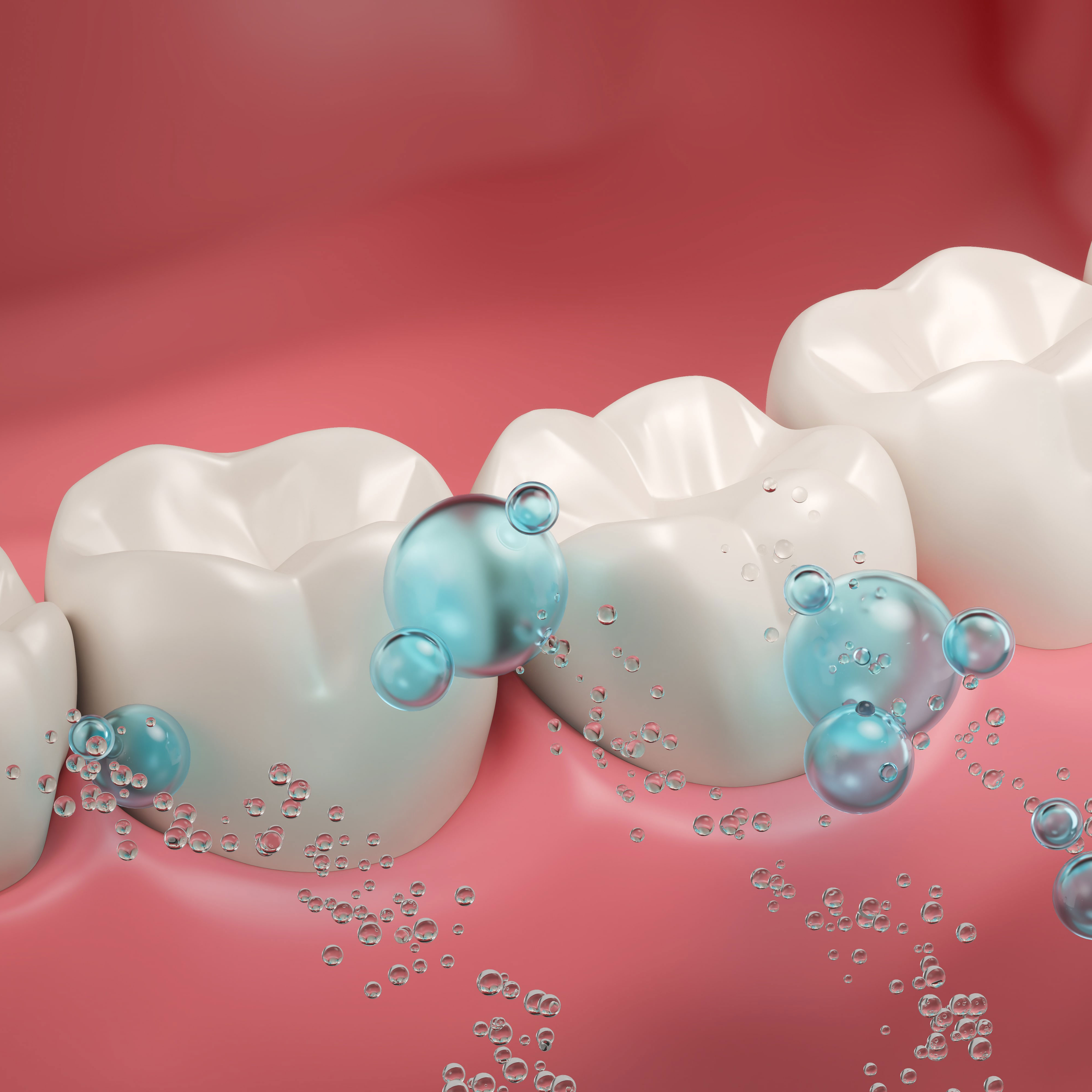 A man with a beard is wearing a white shirt and smiling with his arms crossed.