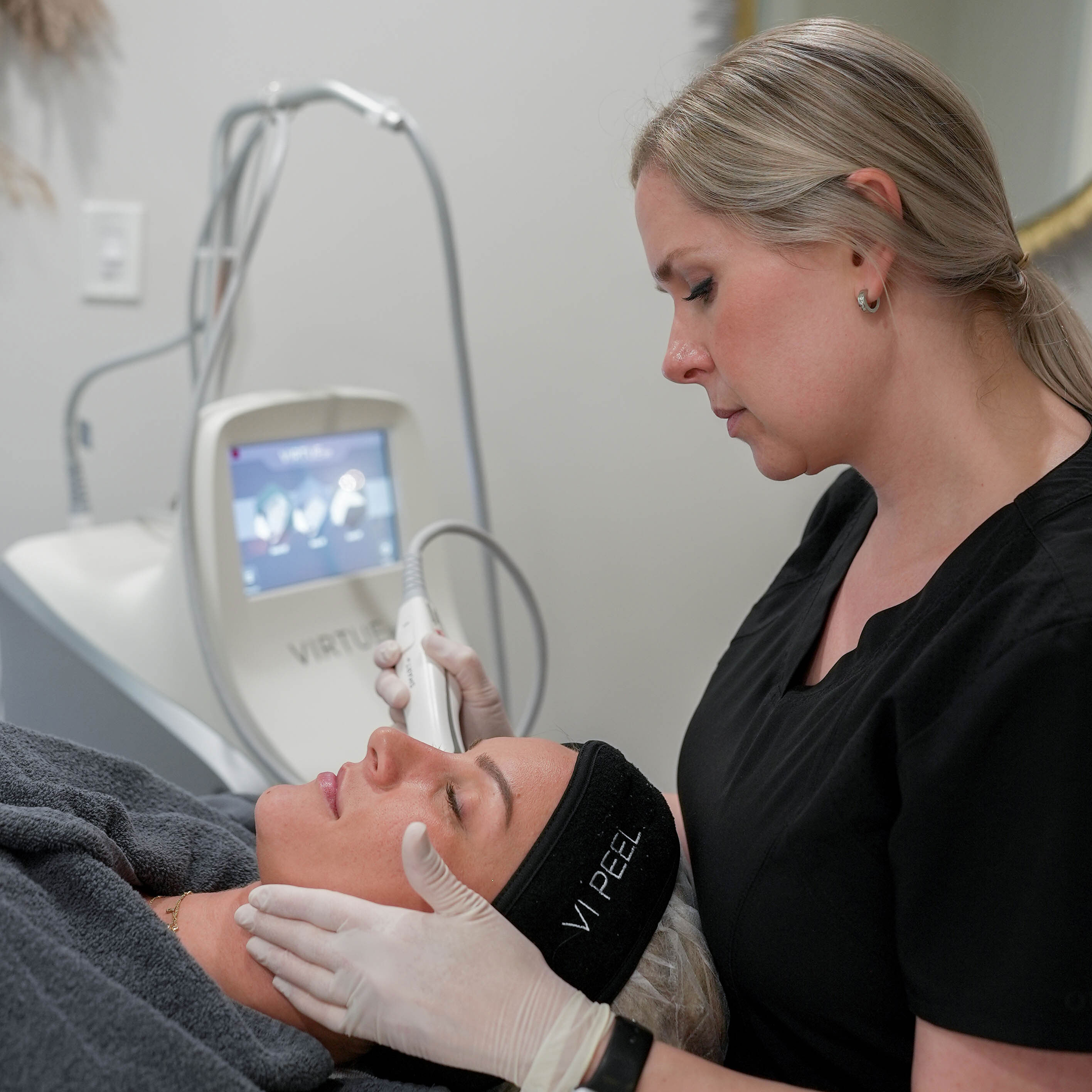 A man with a beard is wearing a white shirt and smiling with his arms crossed.