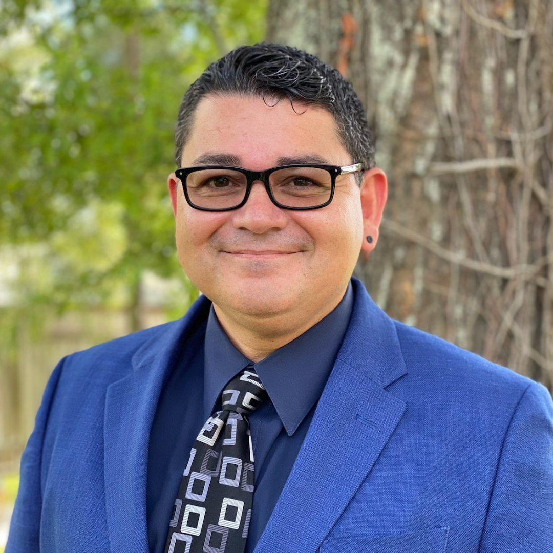 a woman wearing a black jacket and a red scarf is smiling for the camera .