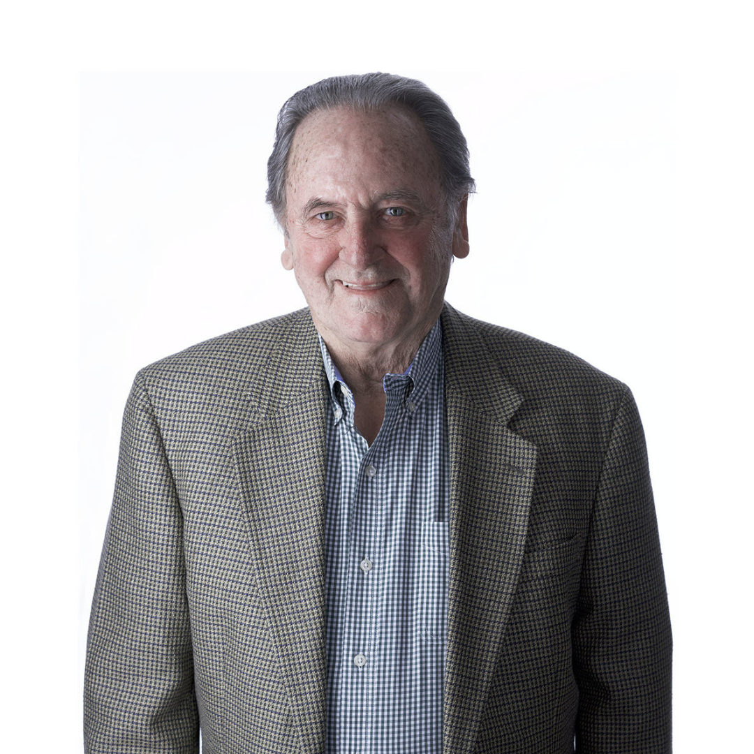 a woman wearing a black jacket and a red scarf is smiling for the camera .