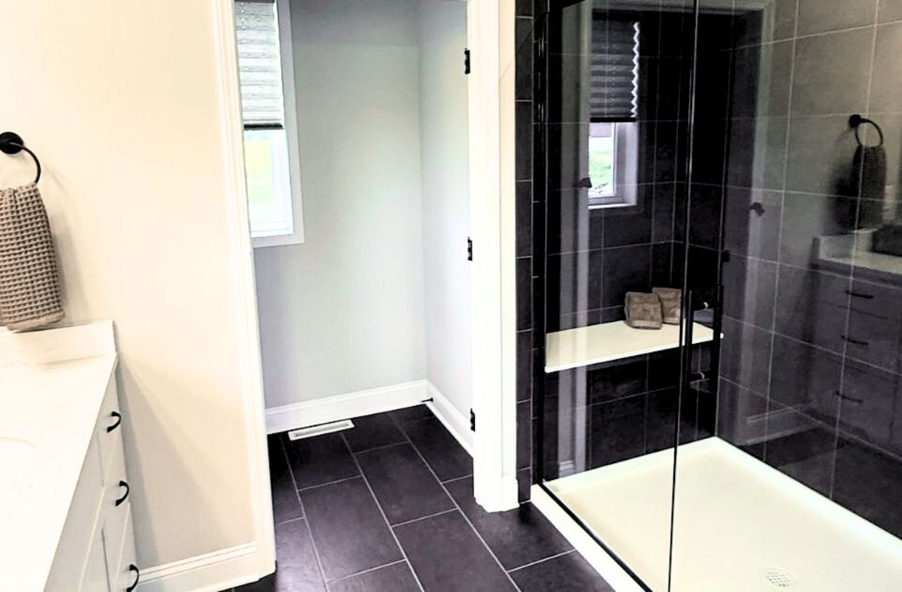 18 Dahlia Drive - Lincoln Ranch - Primary Bathroom featuring a large tiled shower with a frameless glass door and a bench