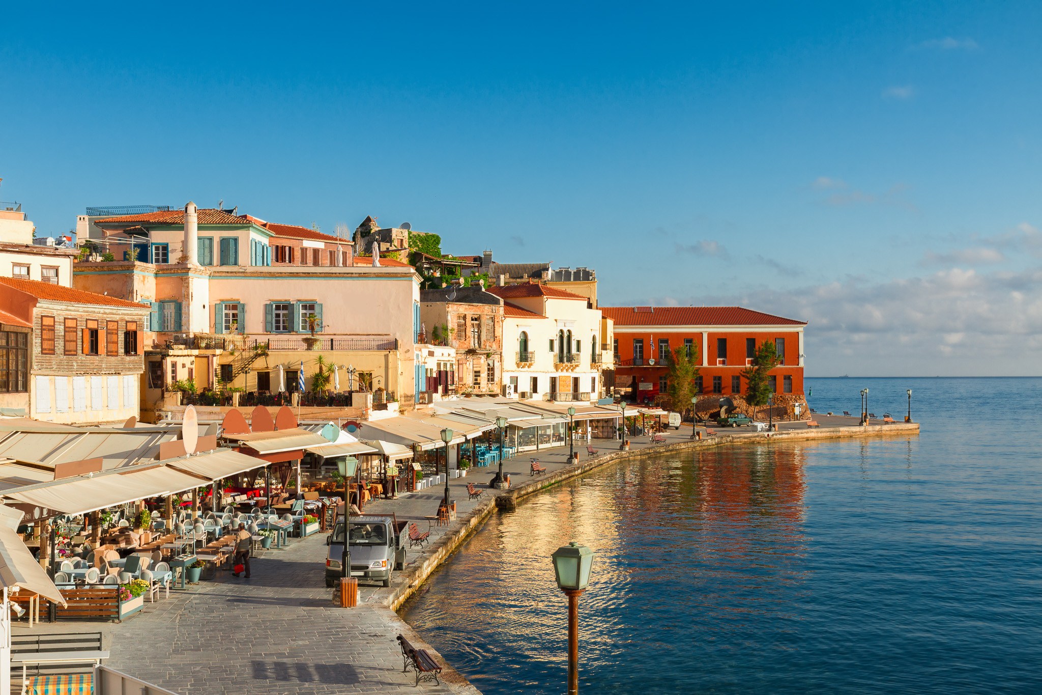 Seaside promenade with colorful buildings and waterfront restaurants in Crete