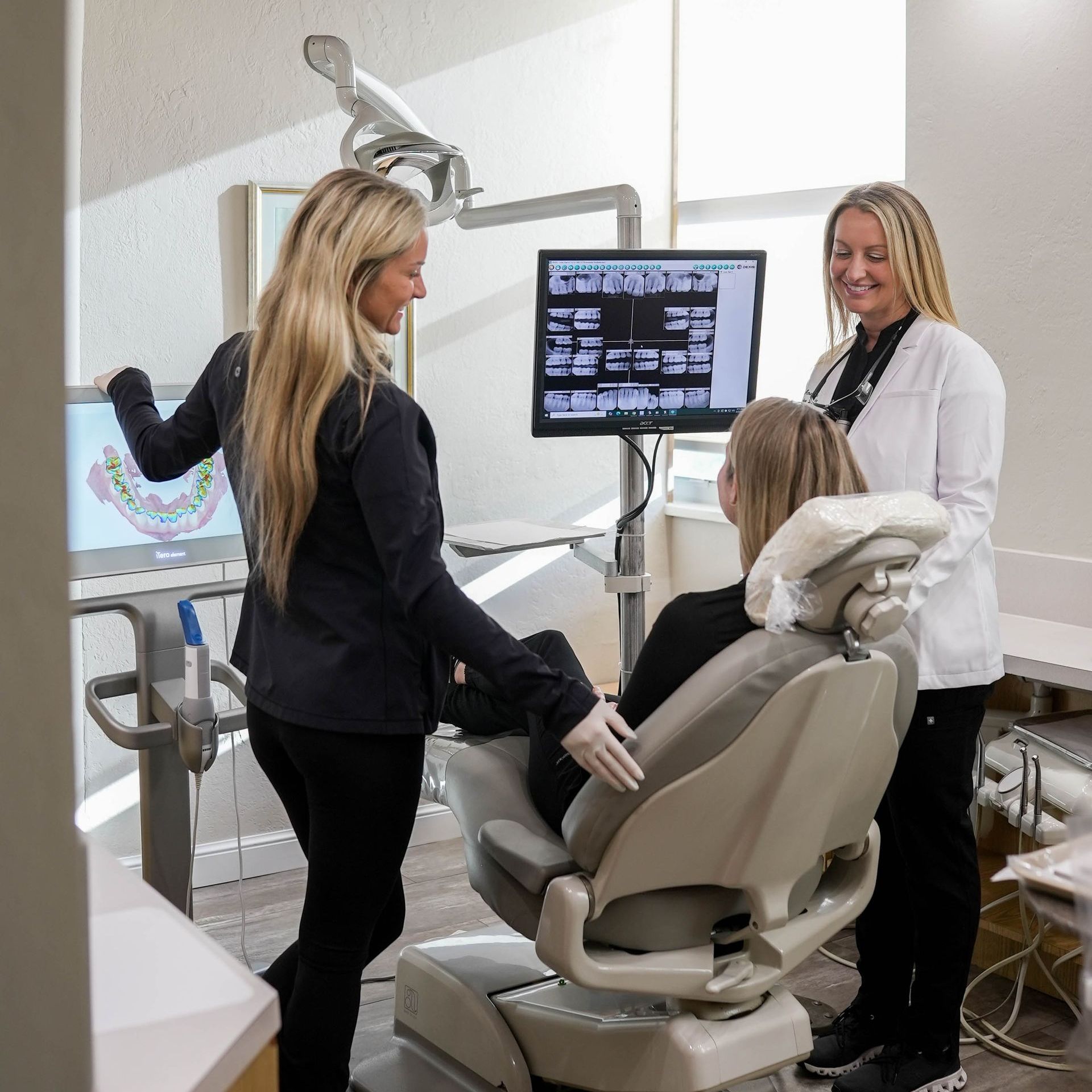 A man with a beard is wearing a white shirt and smiling with his arms crossed.