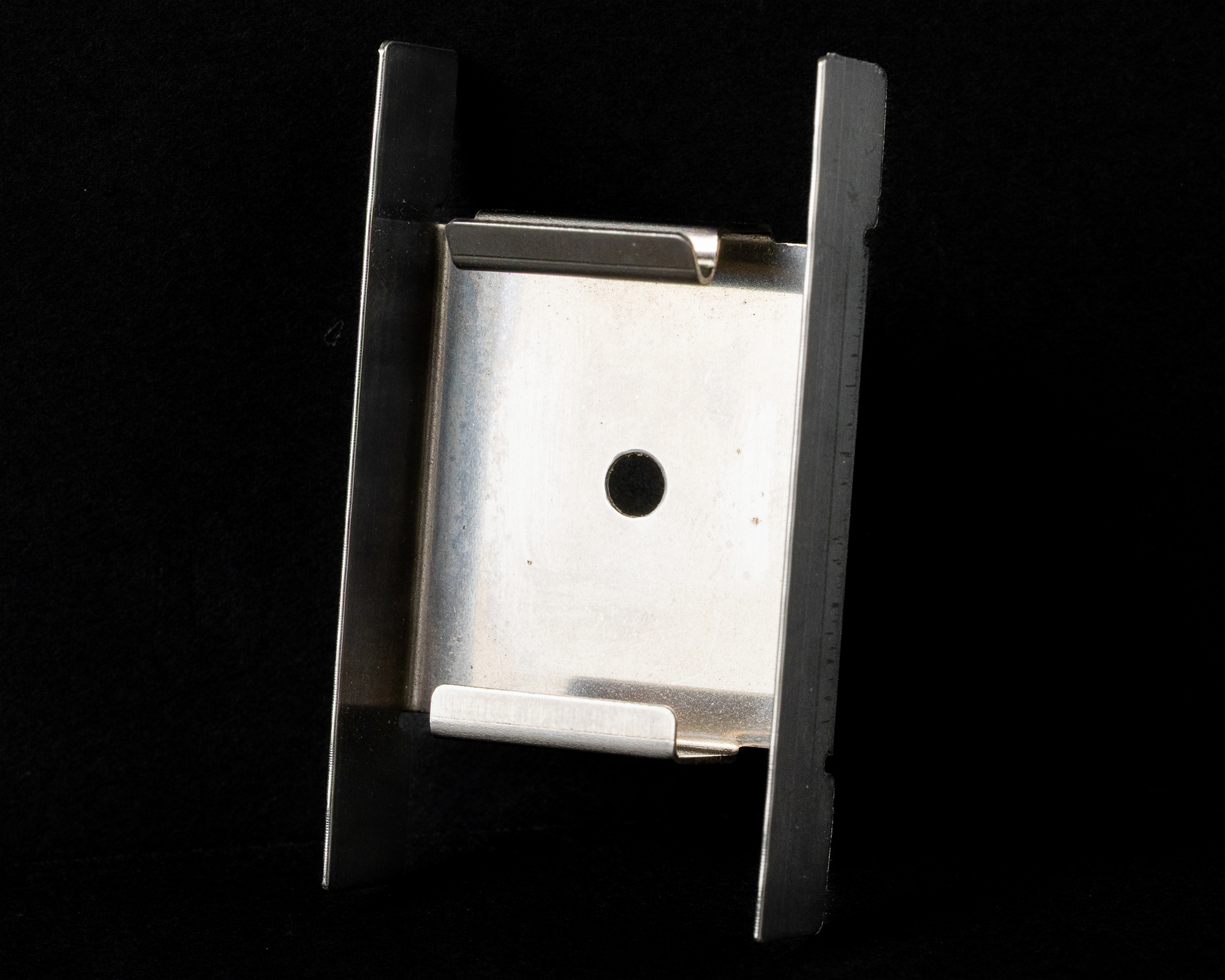 A tightly coiled metal spring against a black background.