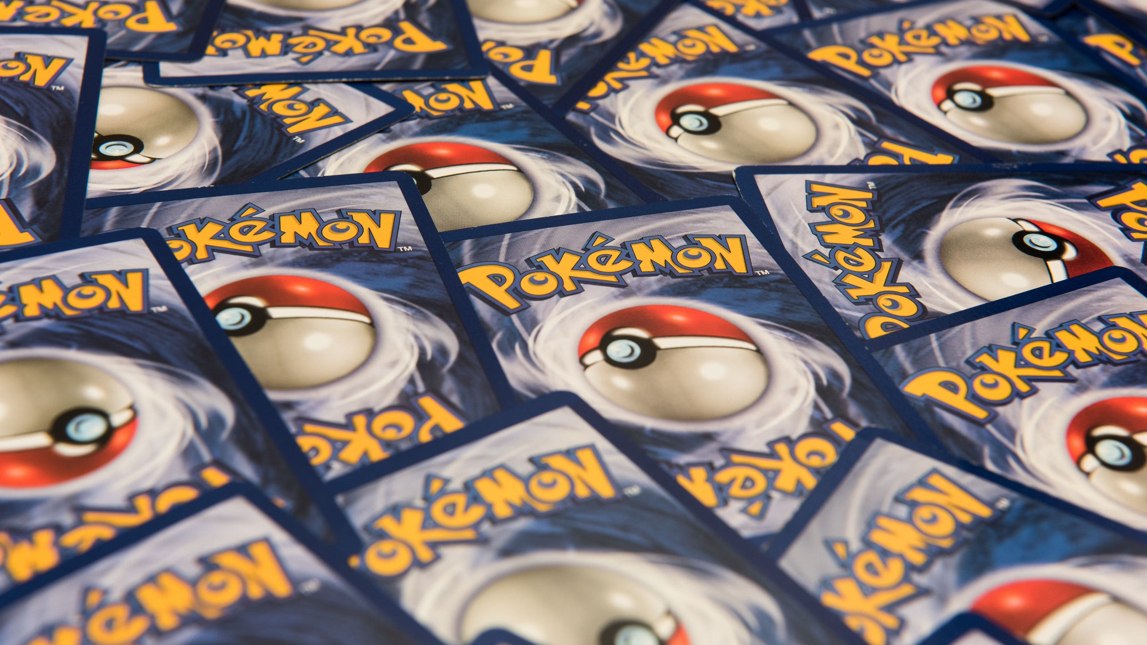 The back of Pokémon Cards stacked next to each other.