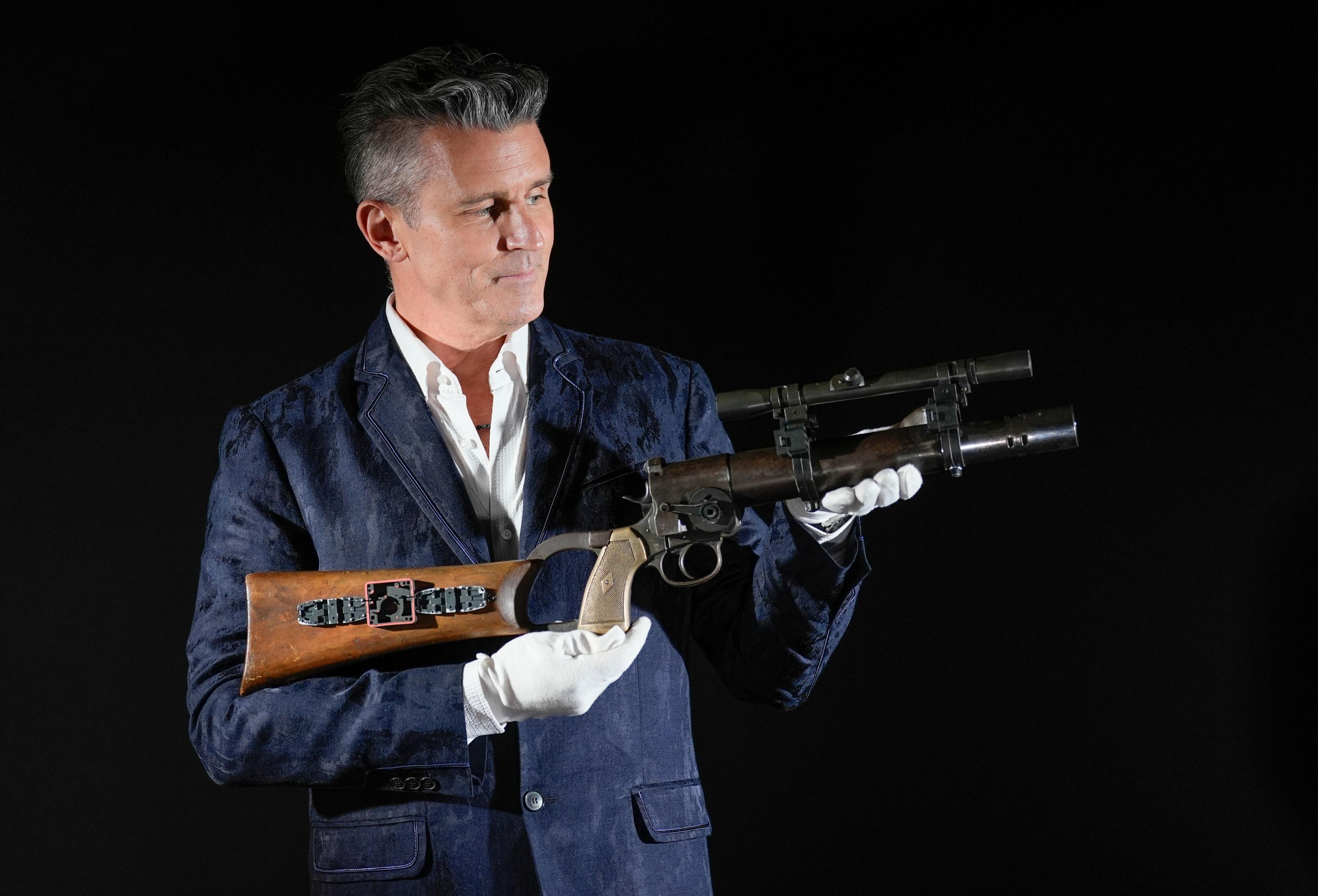 A man holding Boba Fett's (Jeremy Bulloch) Serial Number-Matched EE-3 Carbine Rifle