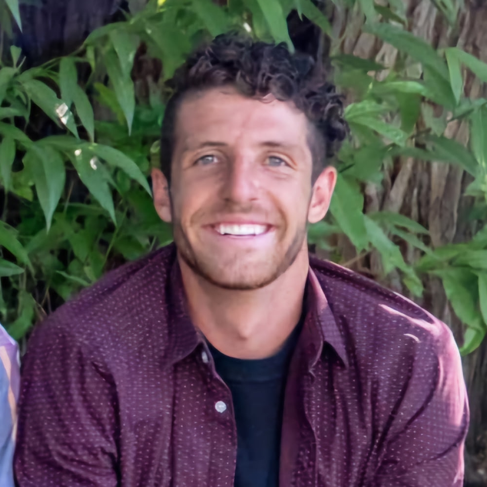 A woman is examining a man 's head in a lab