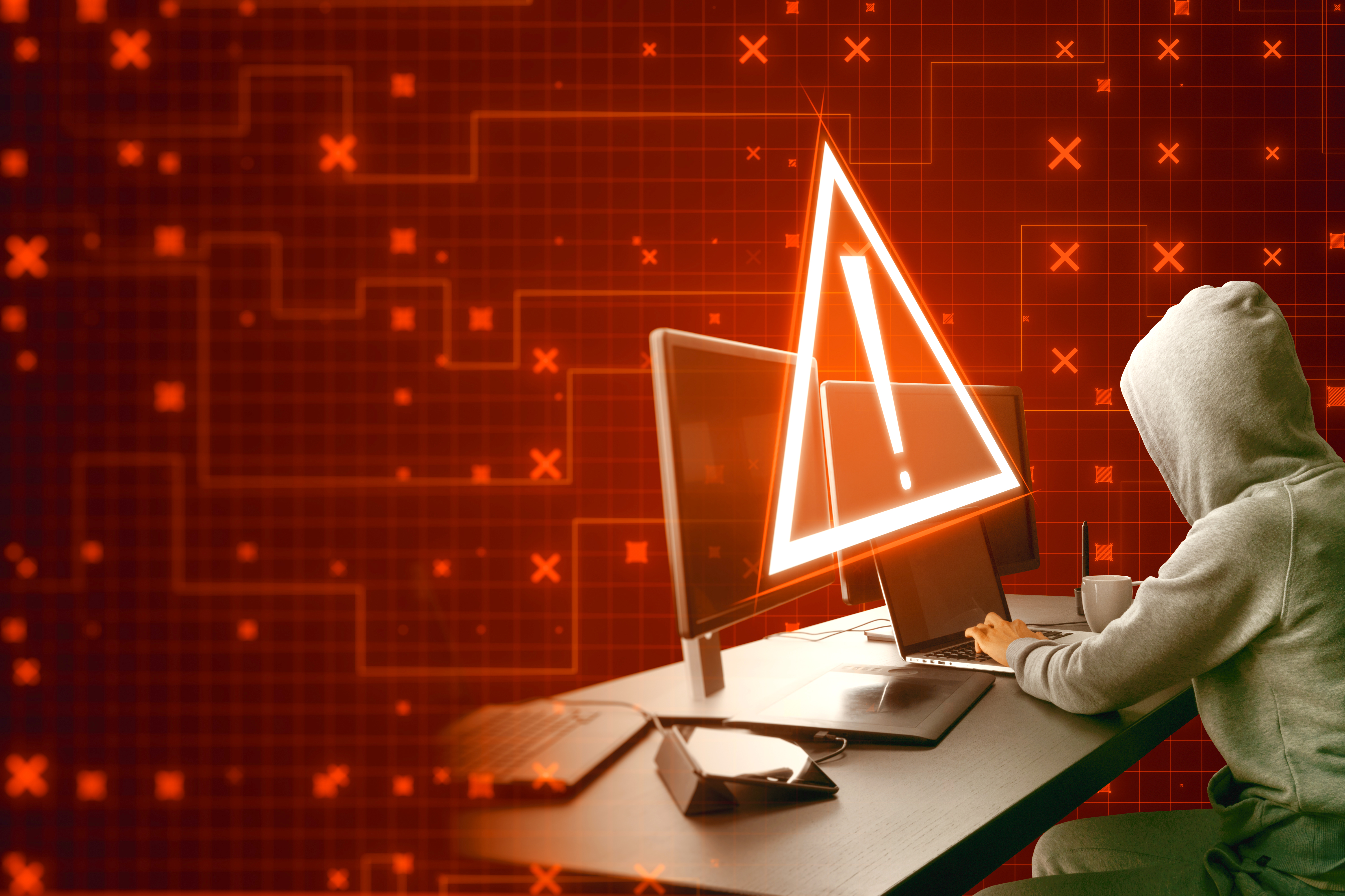 side-view-hacker-using-computers-desktop-with-creative-red-security-alert-blurry-background-fraud-danger-concept (1).jpg
