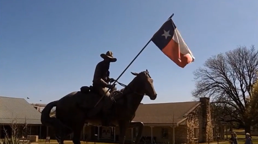 Statue of a ranger on a horse holding a flag in front of the Texas Ranger Hall of Fame and Museum in Waco, TX