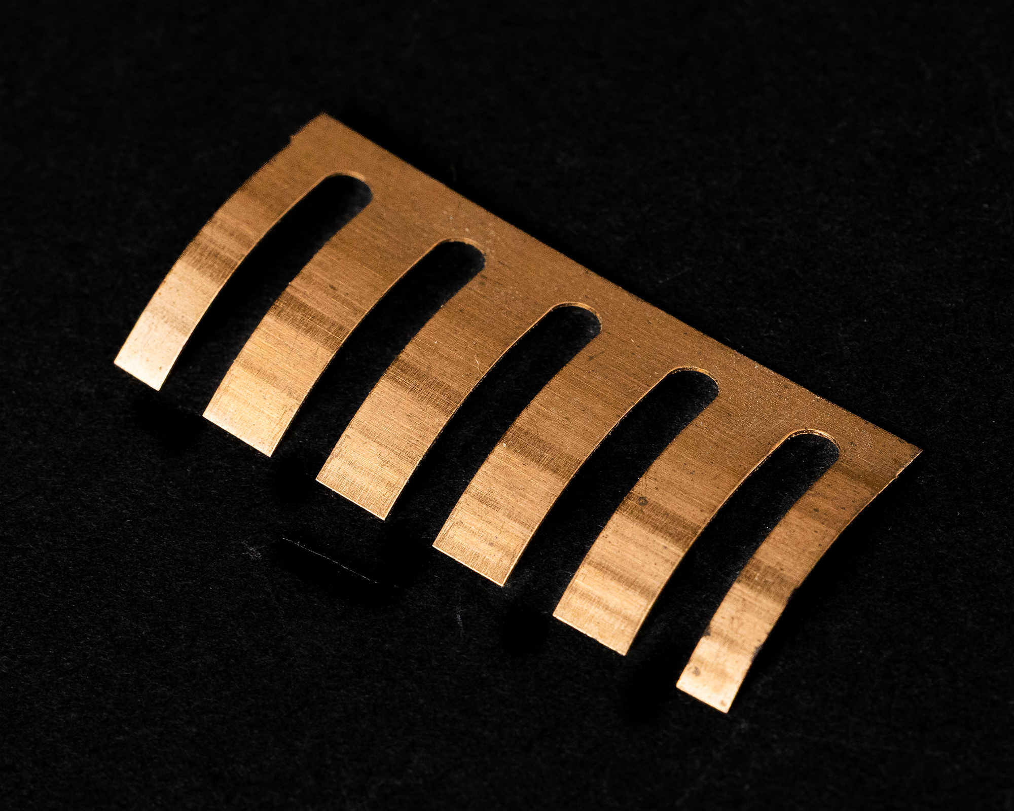 A tightly coiled metal spring against a black background.