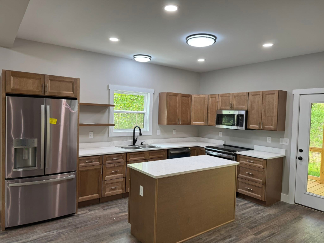 Completed residential kitchen renovation with new cabinets and flooring by Foothills Construction and Restoration Services, call (828) 600-5227.