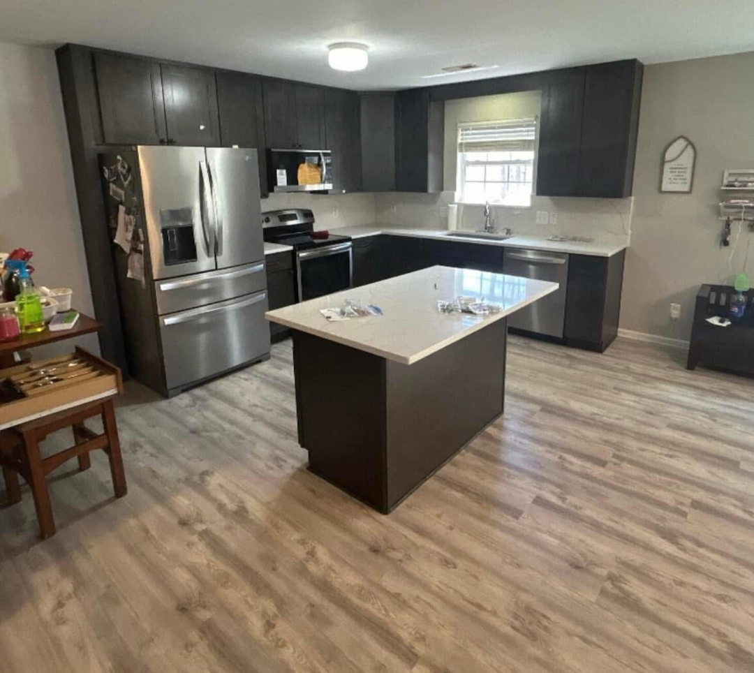 “Completed residential kitchen renovation with new cabinets, island, appliances, and flooring by Foothills Construction and Restoration Services in Asheville, NC. Call (828) 484-0160.