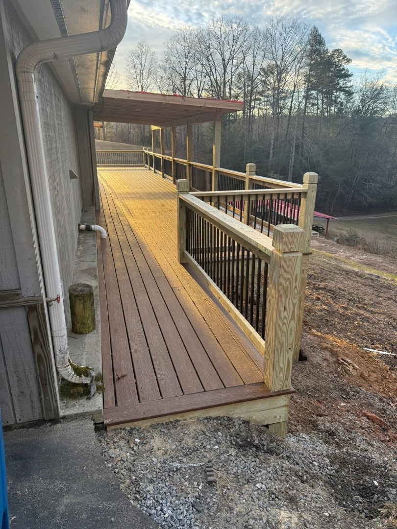 Exterior wooden deck with railing and covered section built by Foothills Construction and Restoration Services in Asheville, NC. Call (828) 484-0160.