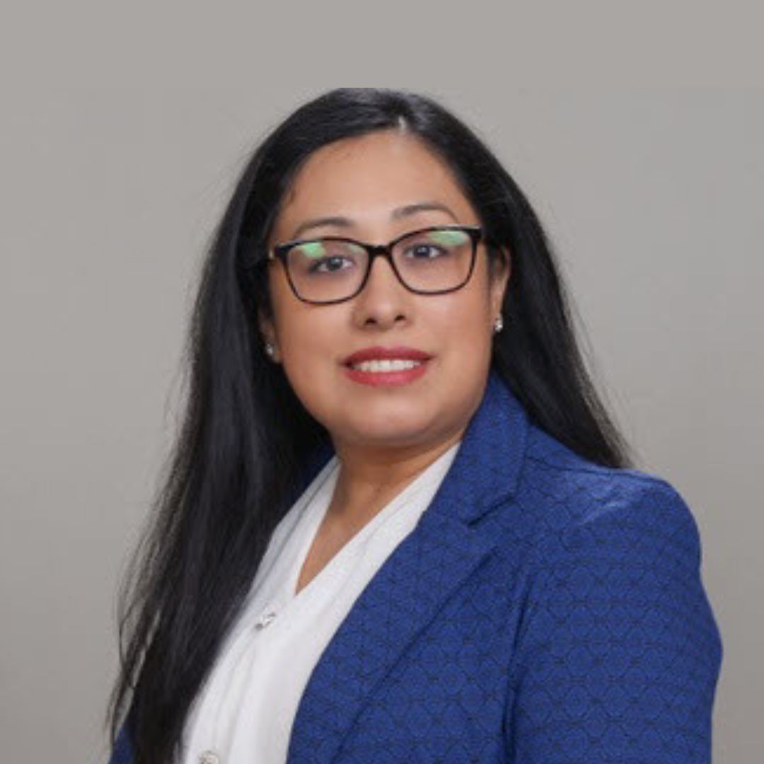 a woman wearing a black jacket and a red scarf is smiling for the camera .