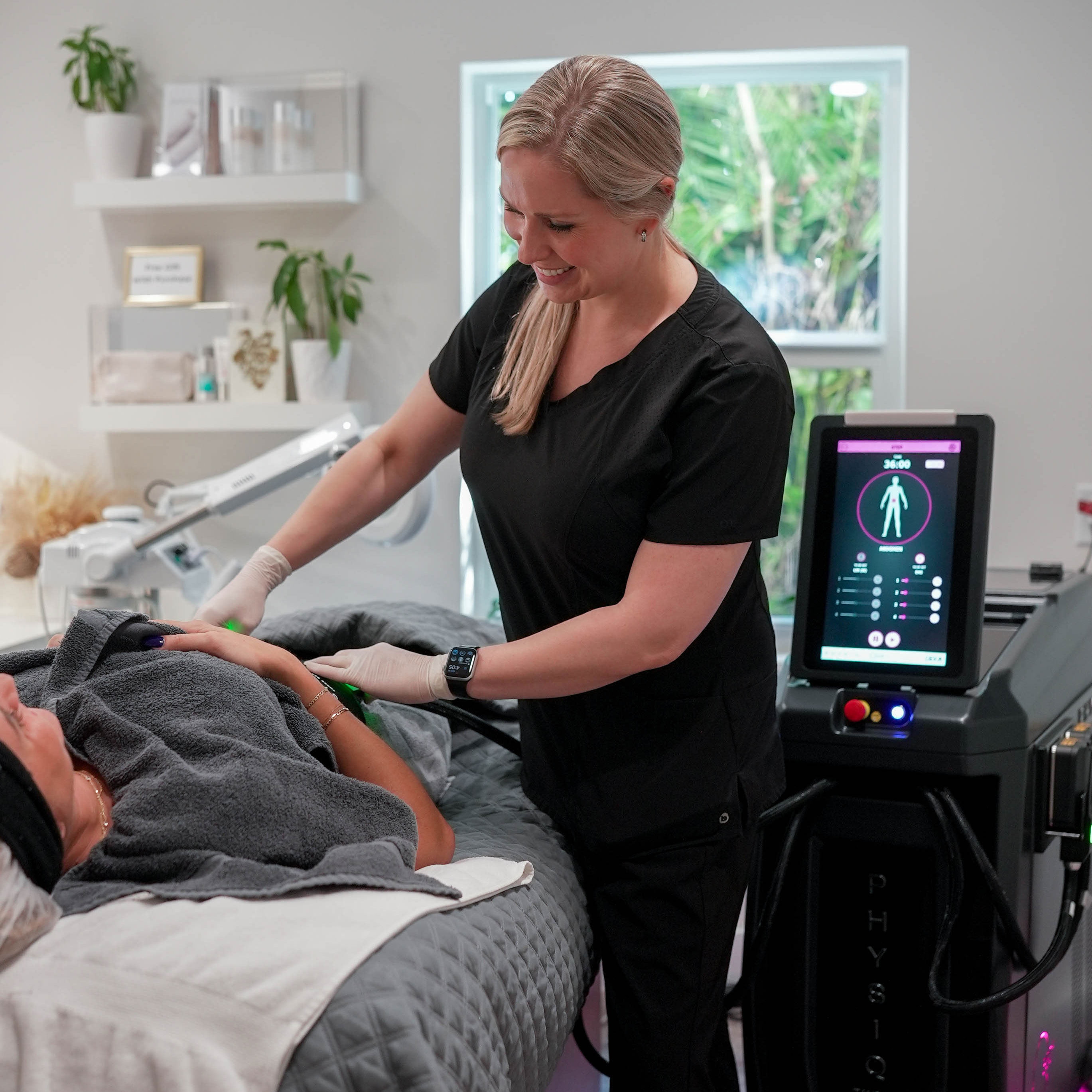 A man with a beard is wearing a white shirt and smiling with his arms crossed.