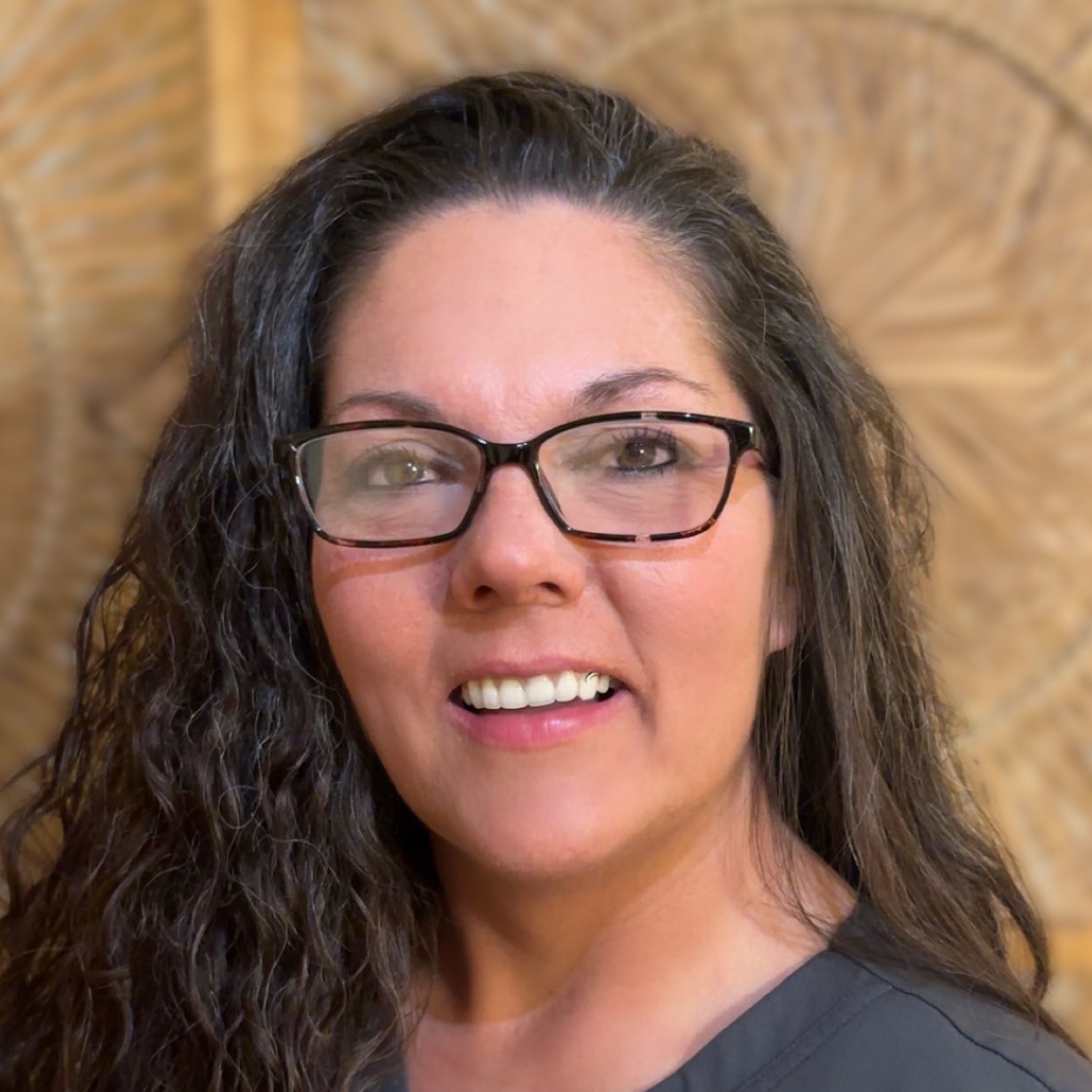 A woman is examining a man 's head in a lab