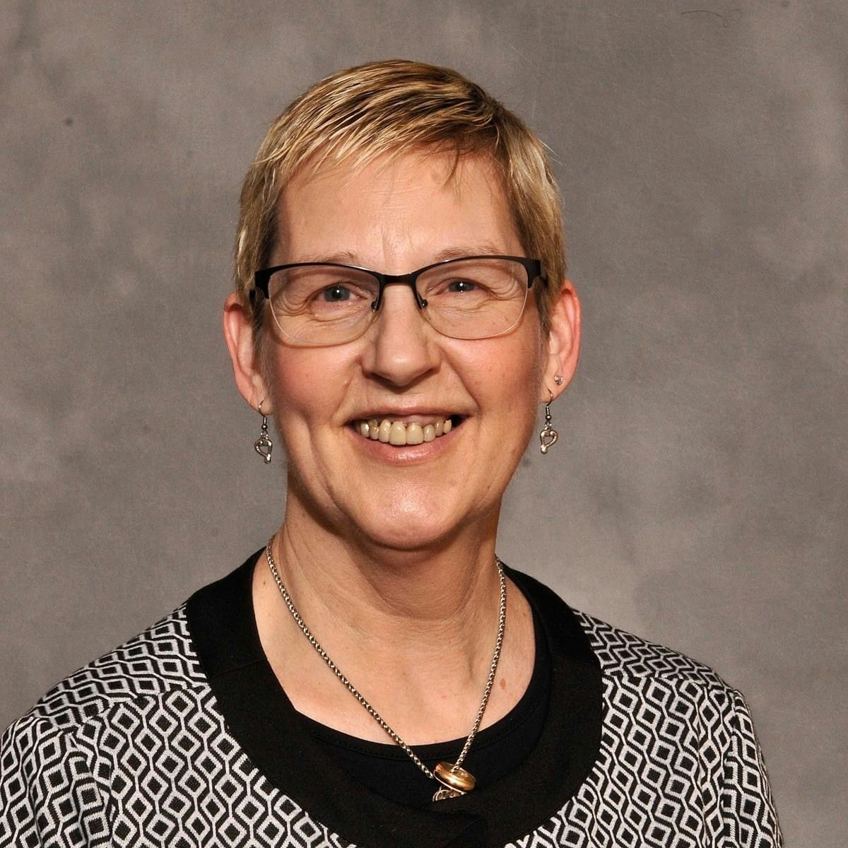 A woman is examining a man 's head in a lab