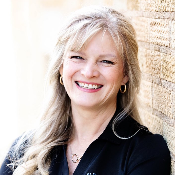 A woman is examining a man 's head in a lab