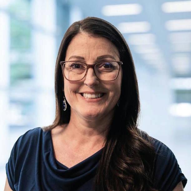 A woman is examining a man 's head in a lab