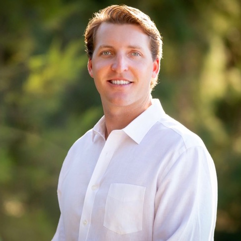 A woman is examining a man 's head in a lab