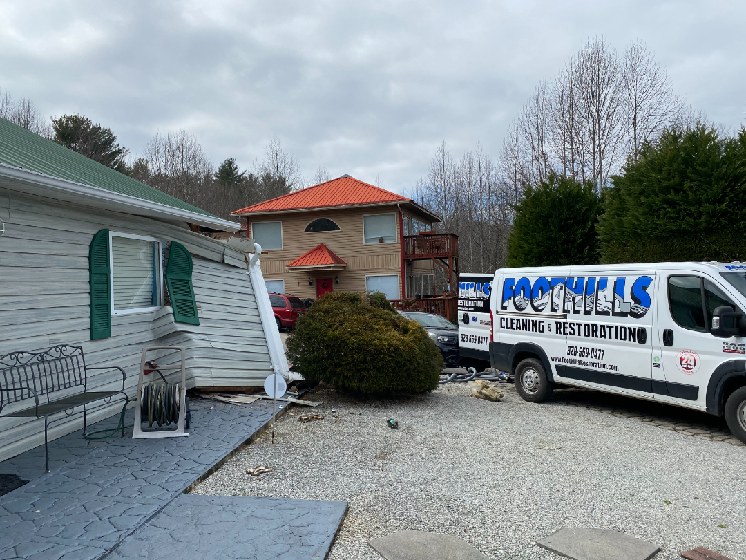 Foothills Construction and Restoration Services vehicles parked at a residential restoration job site in Morganton, NC. Phone (828) 373-1194.