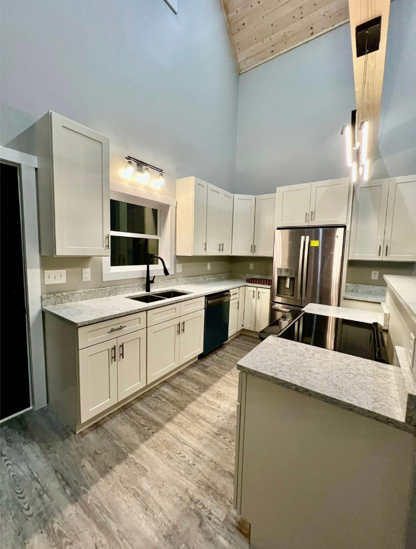 Completed kitchen renovation with new cabinets, countertops, appliances, and lighting by Foothills Construction and Restoration Services in Morganton, NC. Call (828) 373-1194.