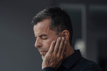 Man holding his ear in pain