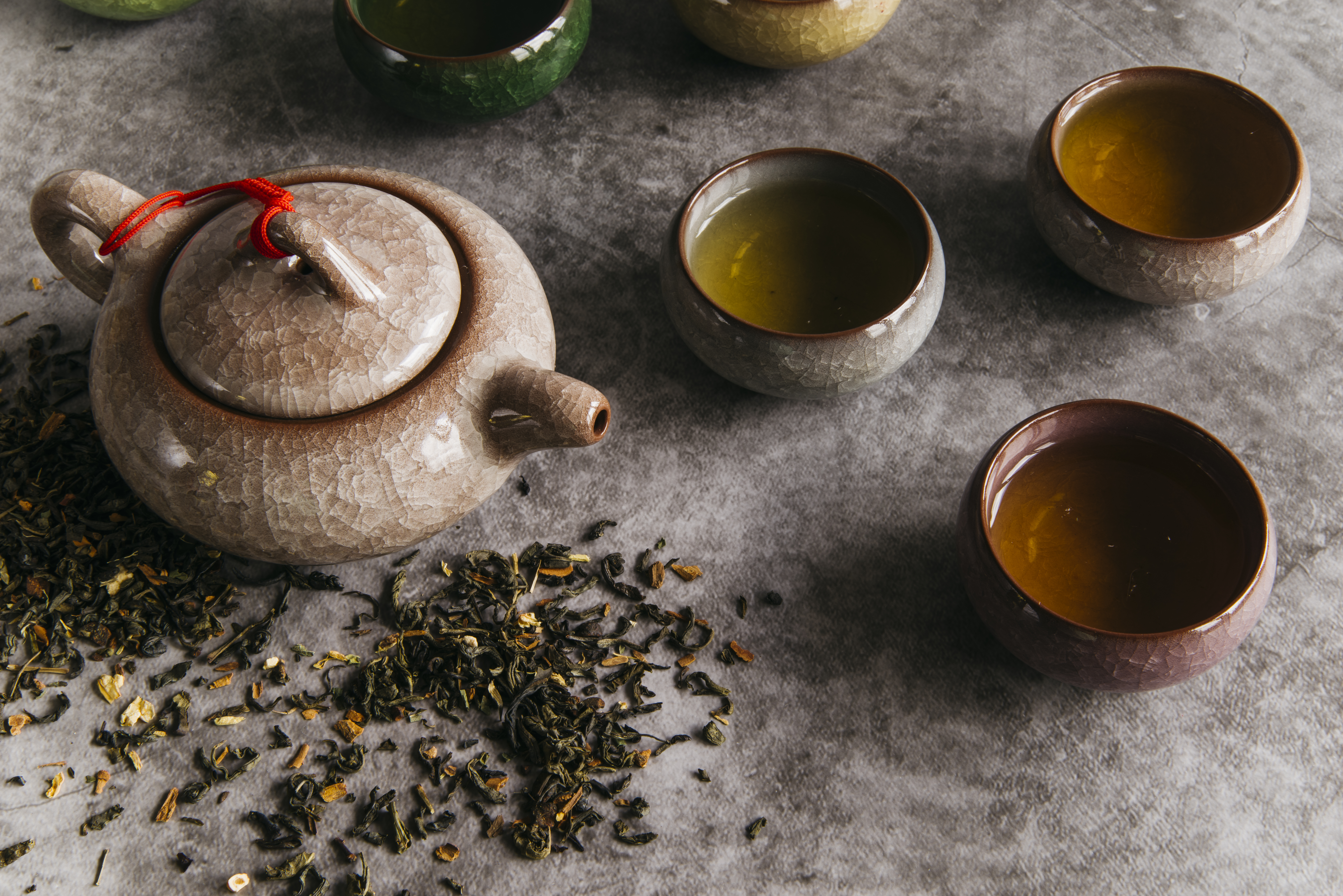 chinese-brown-teapot-teacups-with-tea-herbs-concrete-backdrop.jpg