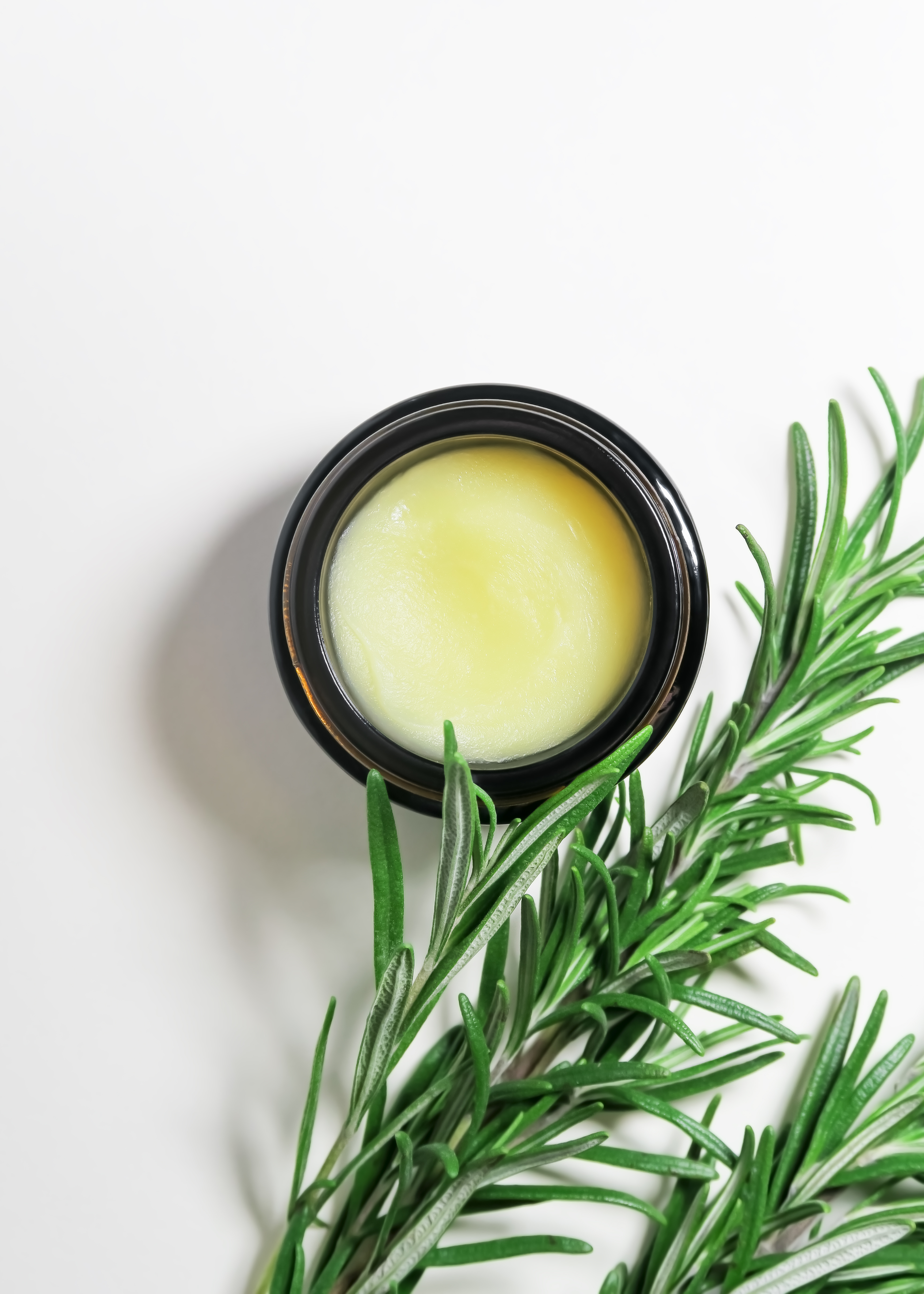 solid-cosmetic-oil-with-rosemary-extract-glass-jar-fresh-rosemary-branches-white-backg.jpg