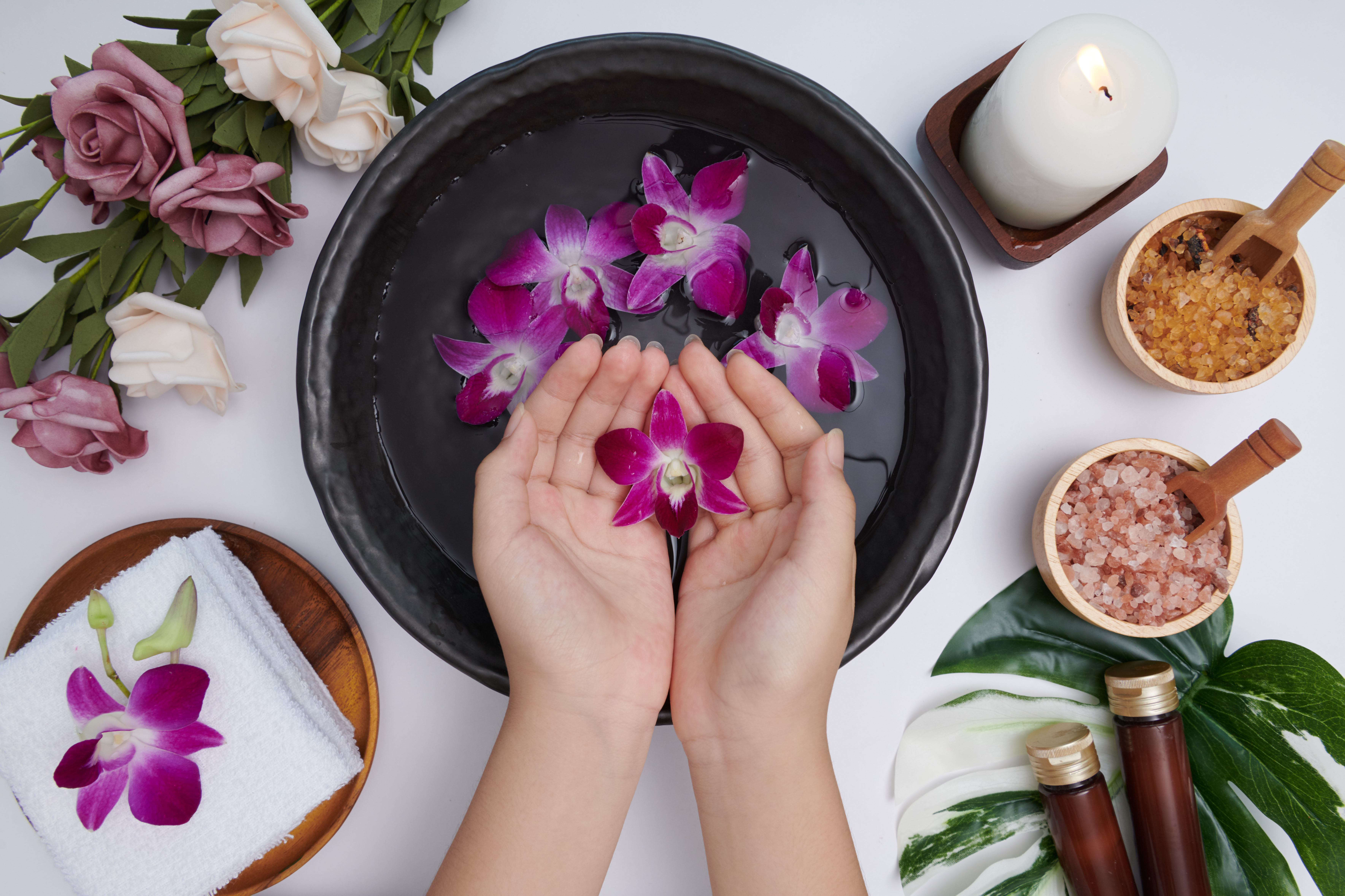 woman-soaking-her-hands-bowl-water-flowers-spa-treatment-product-female-feet-hand-spa-massage-pebble-perfumed-flowers-water-candles-relaxation-flat-lay-top-view.jpg