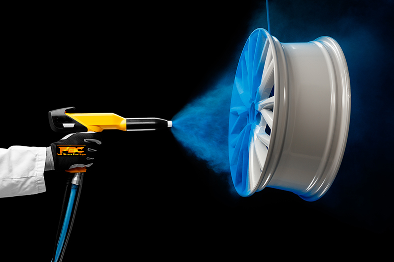 Precision powder coating being applied to a silver wheel rim with a blue spray.