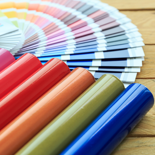 Color swatch fan spread out next to glossy powder coating color sample tubes in red, orange, green, and blue