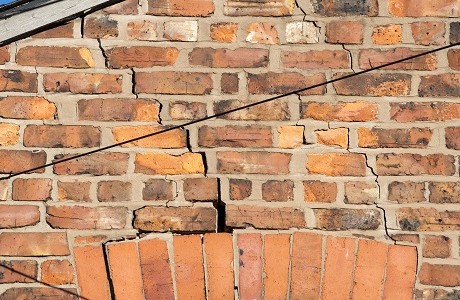 A brick wall with cracks in it