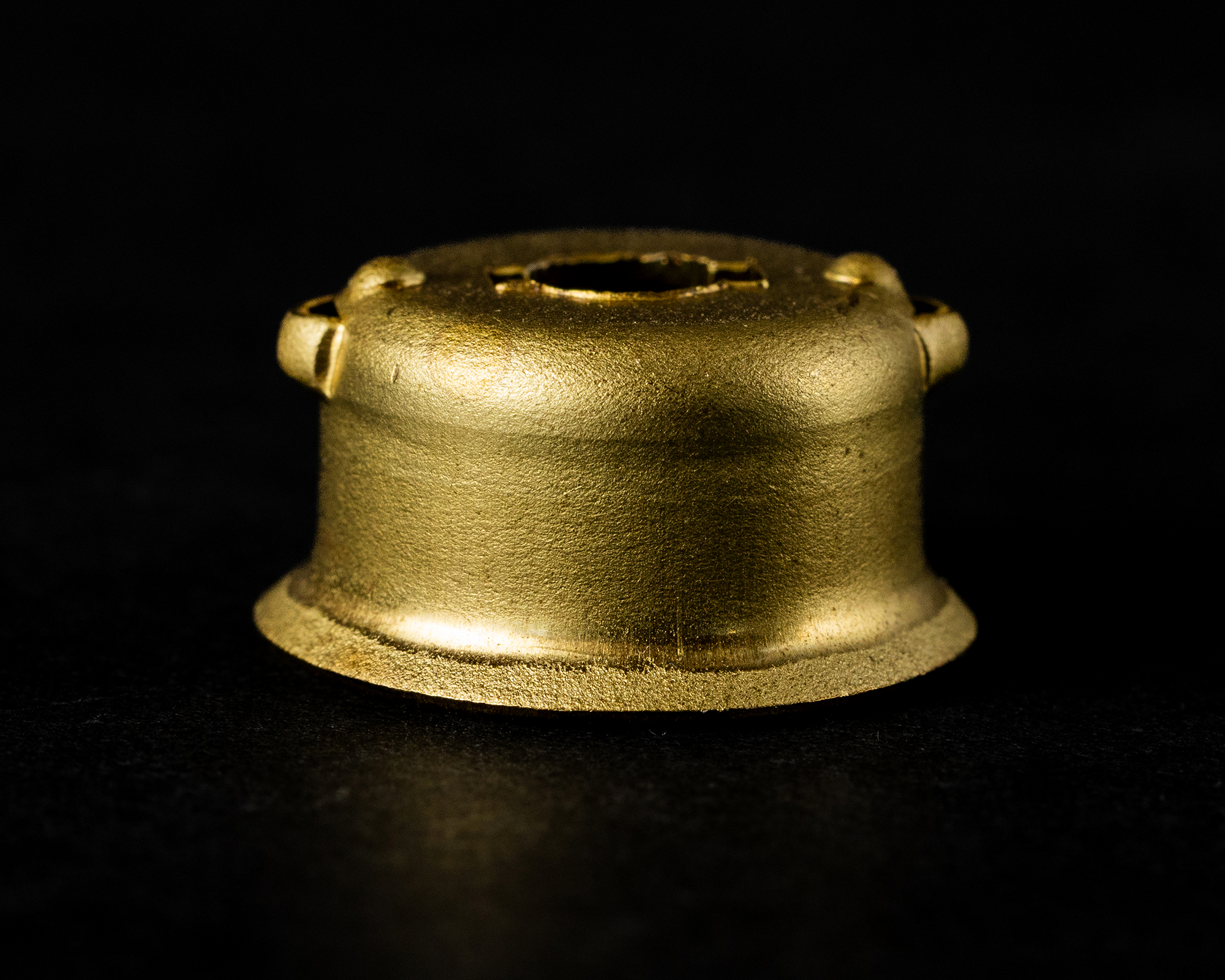 Golden coil spring against a black background.