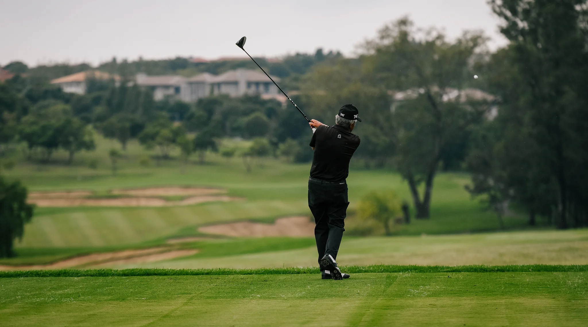 Ein Golfwagen auf einem Golfplatz mit Palmen im Hintergrund