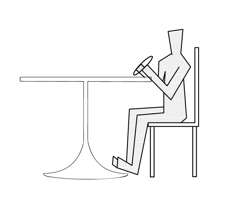 a person sitting while eating a sub sandwich 