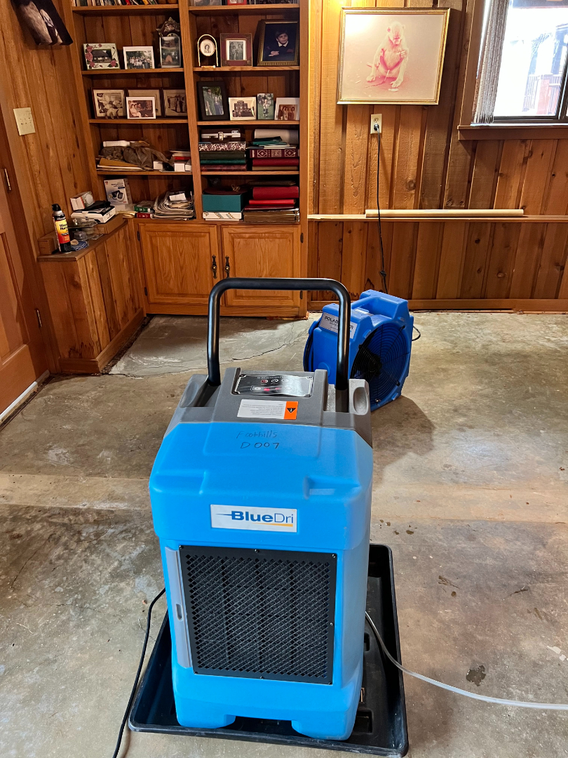 Interior room with professional dehumidifier and air mover set up for water damage restoration by Foothills Construction and Restoration Services in Forest City, NC. Call (828) 537-4470.