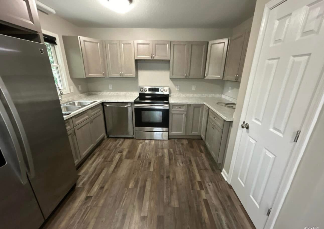 Finished kitchen renovation with new cabinets, appliances, and flooring completed by Foothills Construction and Restoration Services in Forest City, NC. Call (828) 537-4470.