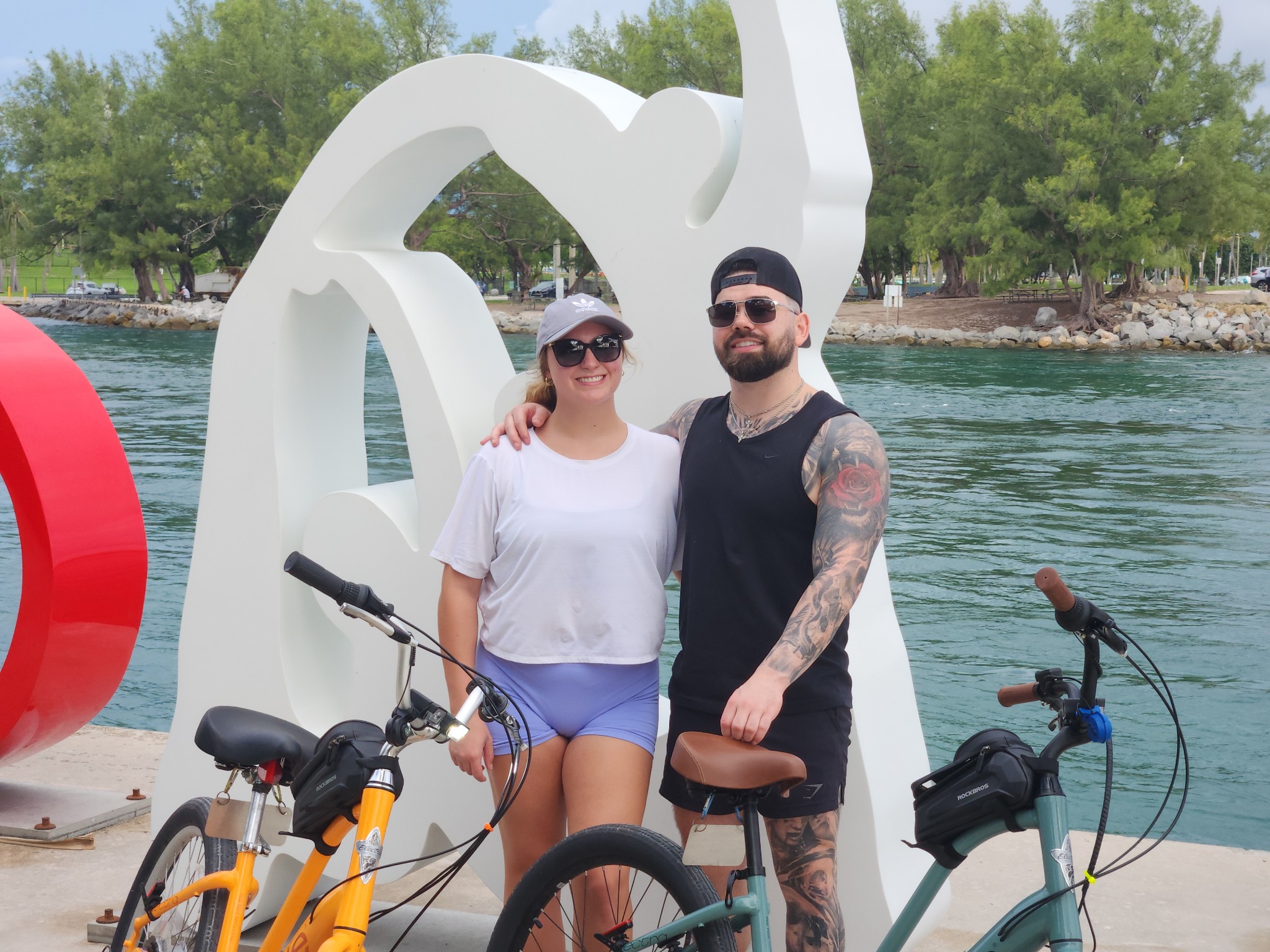 A young couple with e-bikes in front of a bay