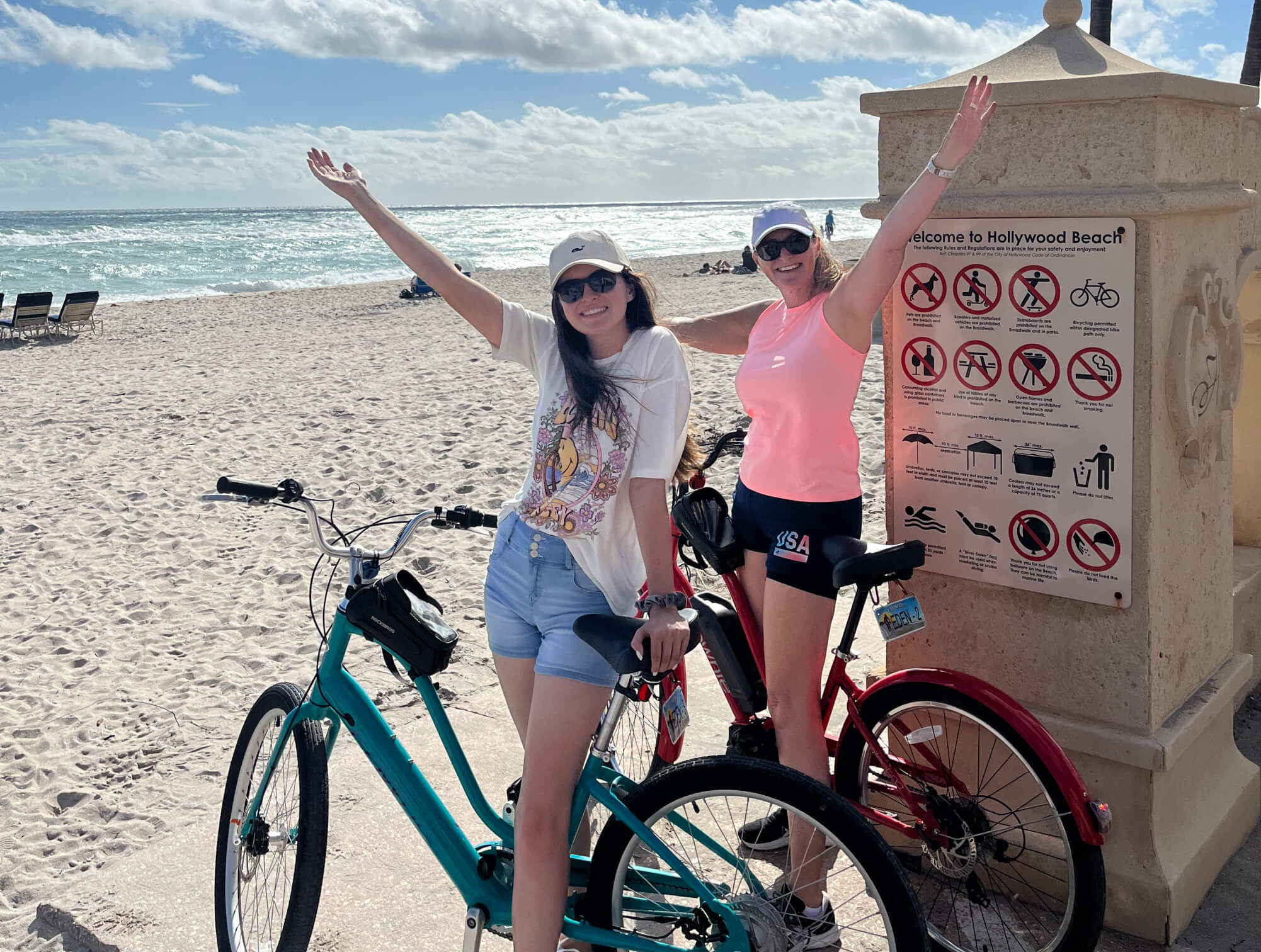Mom and daughter holding ebikes on hollywood beach