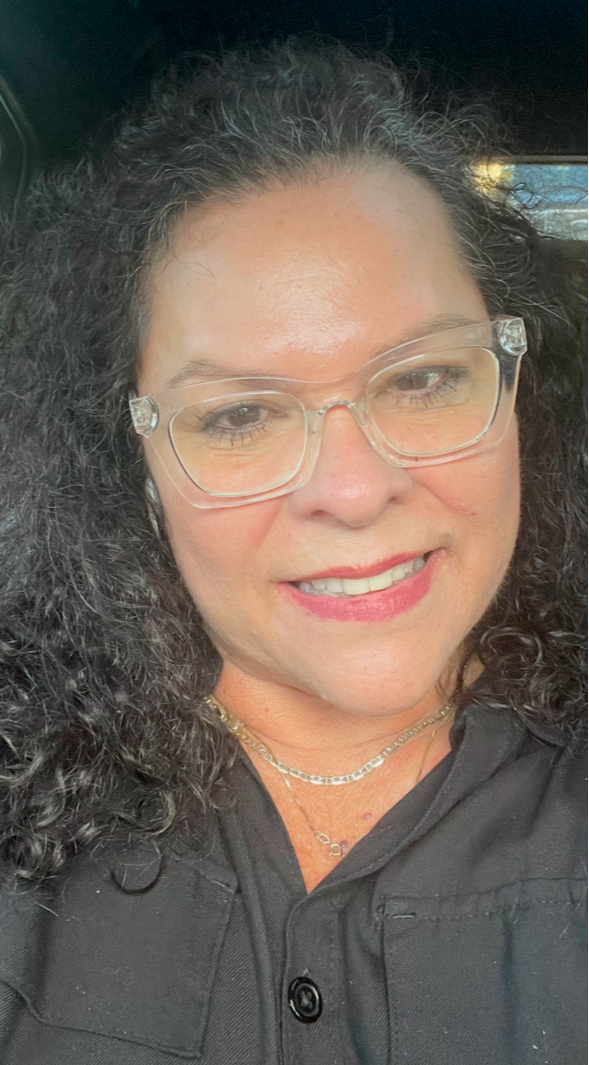 a woman wearing a black jacket and a red scarf is smiling for the camera .